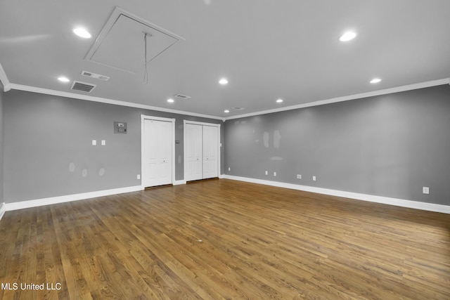 spare room featuring attic access, recessed lighting, baseboards, and wood finished floors