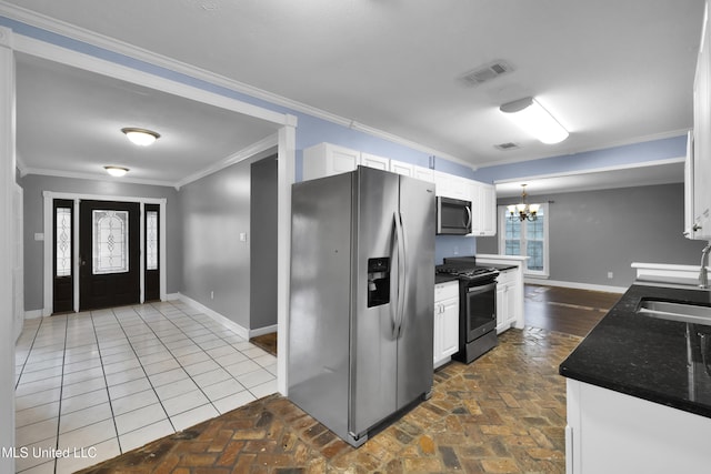 kitchen with a chandelier, stainless steel appliances, ornamental molding, and a sink