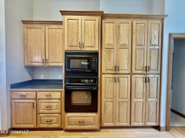 110 Frye Rd, Hattiesburg, MS 39401 - kitchen featuring black appliances, light wood-style flooring, light brown cabinetry, and dark countertops