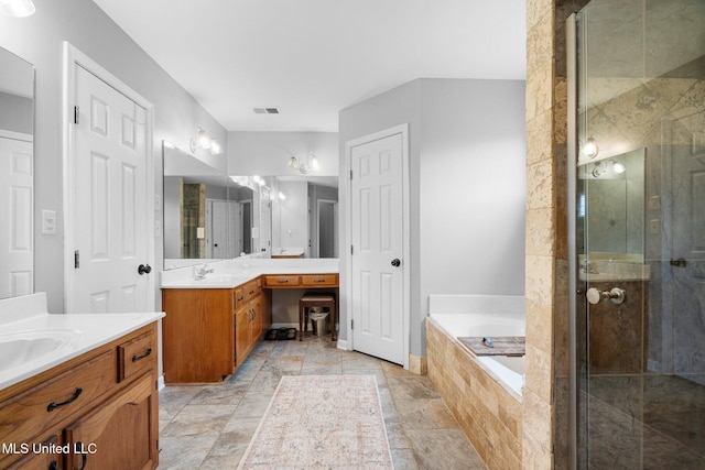bathroom with vanity, a stall shower, a bath, and visible vents