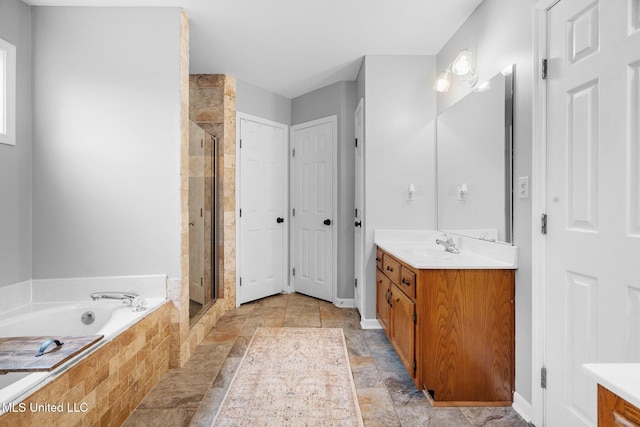 full bathroom with vanity, a bath, and a stall shower