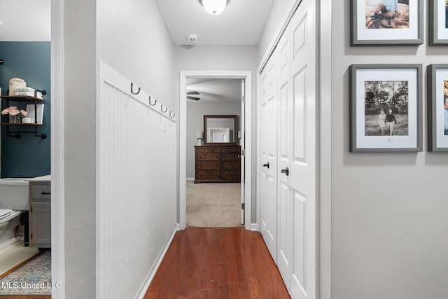 corridor with dark wood-style flooring and baseboards