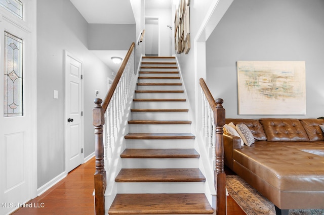 staircase with baseboards and wood finished floors