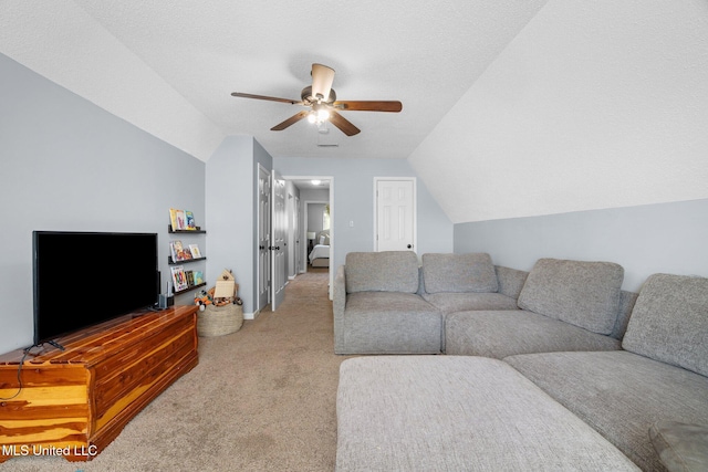 living area with baseboards, ceiling fan, vaulted ceiling, and light carpet