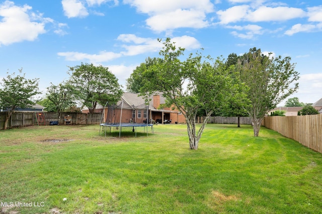 view of yard with a fenced backyard and a trampoline