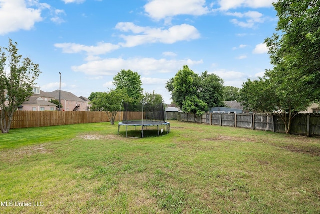 view of yard featuring a fenced backyard and a trampoline