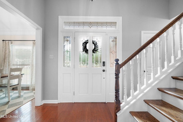 entrance foyer featuring baseboards, stairs, and wood finished floors