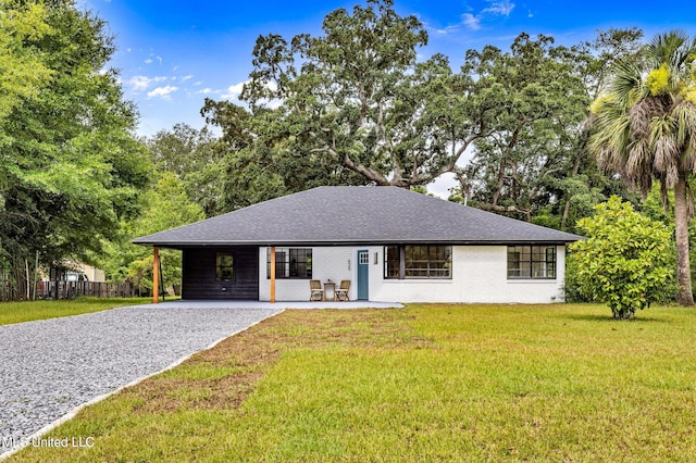 ranch-style home featuring a front lawn and a carport