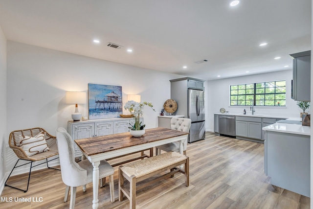 dining area featuring sink and light hardwood / wood-style floors