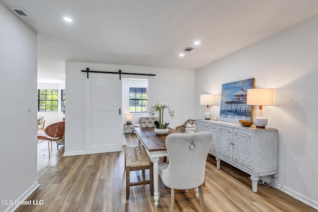 dining space featuring light hardwood / wood-style floors and a barn door