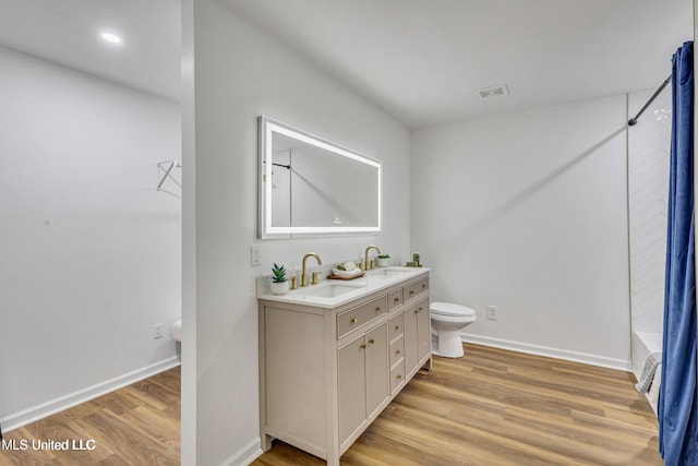 full bathroom featuring vanity, shower / washtub combination, hardwood / wood-style floors, and toilet