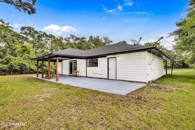 back of property with a lawn and a patio