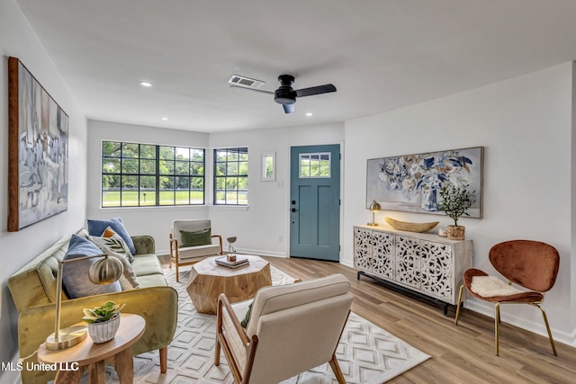 living room featuring light hardwood / wood-style flooring and ceiling fan