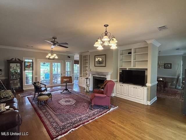9053 Castalian Springs Rd, Durant, MS 39063 - living area with visible vents, a high end fireplace, built in features, wood finished floors, and ceiling fan with notable chandelier