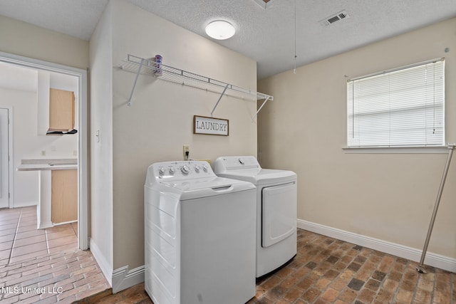 laundry area featuring washing machine and dryer and a textured ceiling