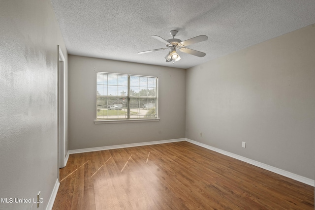 empty room featuring ceiling fan, wood-type flooring, and a textured ceiling