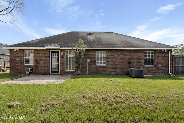 rear view of property featuring a patio, cooling unit, and a lawn