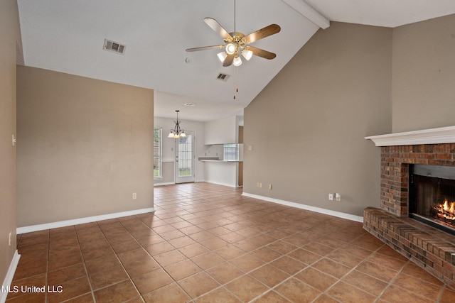 unfurnished living room with beam ceiling, high vaulted ceiling, a brick fireplace, ceiling fan with notable chandelier, and tile patterned flooring