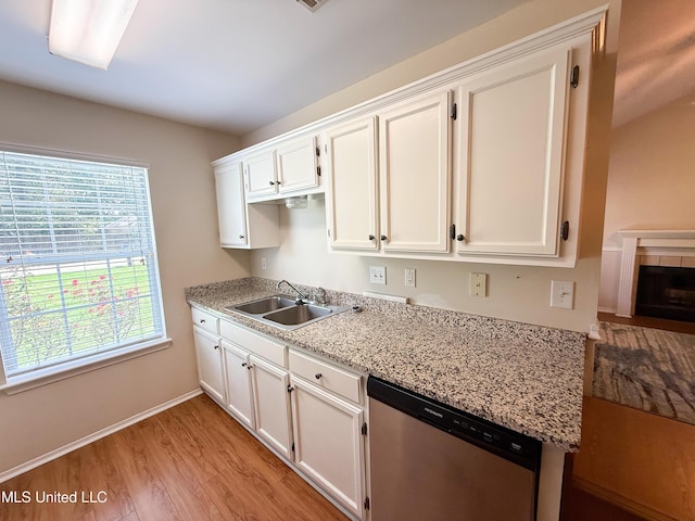 999 Hamakua St, Diamondhead, MS 39525 - kitchen featuring dishwasher, light wood finished floors, white cabinets, and a tiled fireplace