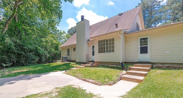 828 Briarwood Dr, Jackson, MS 39211 - back of property featuring central AC unit, a chimney, a yard, and entry steps