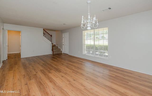 828 Briarwood Dr, Jackson, MS 39211 - empty room featuring stairs, light wood-style floors, a chandelier, and baseboards