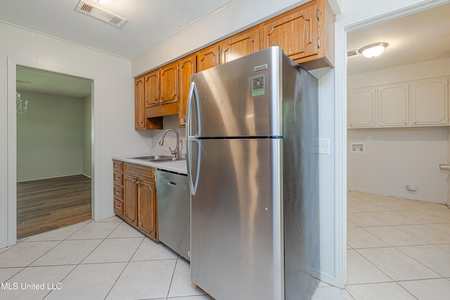 828 Briarwood Dr, Jackson, MS 39211 - kitchen with stainless steel appliances, a sink, light tile patterned flooring, and light countertops