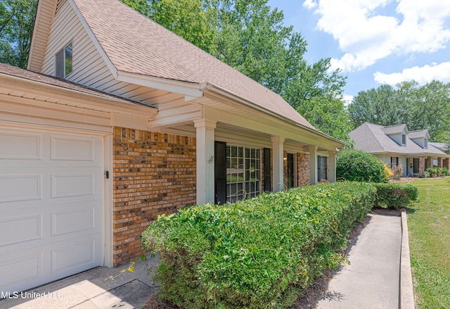 828 Briarwood Dr, Jackson, MS 39211 - view of exterior entry with brick siding, roof with shingles, and an attached garage