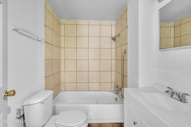 full bathroom with vanity, tiled shower / bath, and toilet