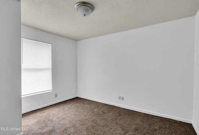 carpeted spare room with a textured ceiling