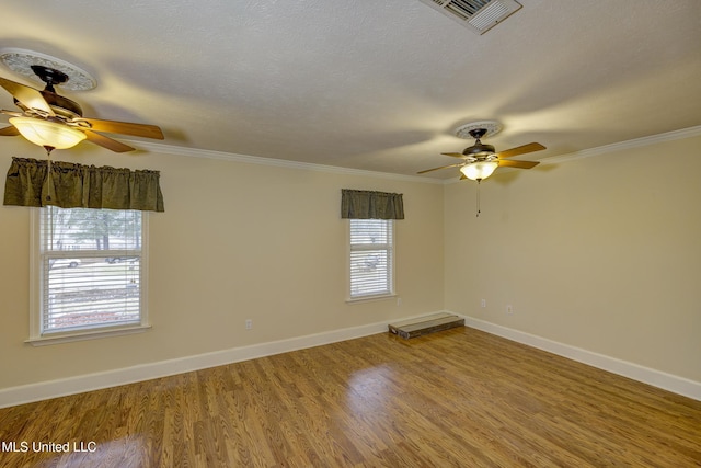 empty room featuring hardwood / wood-style flooring, ornamental molding, and ceiling fan