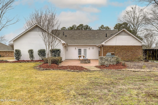 back of house featuring a fire pit, a patio area, and a lawn