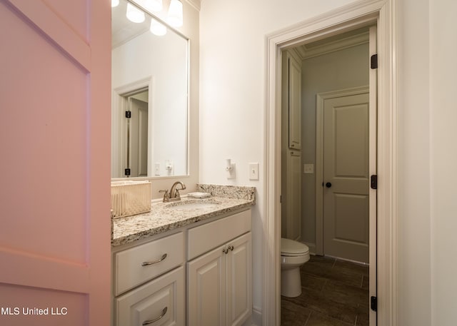 bathroom with vanity, ornamental molding, and toilet