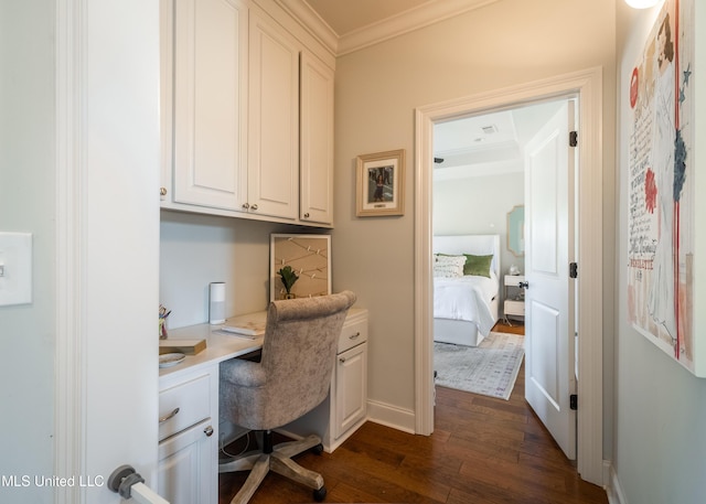 office area featuring dark hardwood / wood-style floors, built in desk, and crown molding