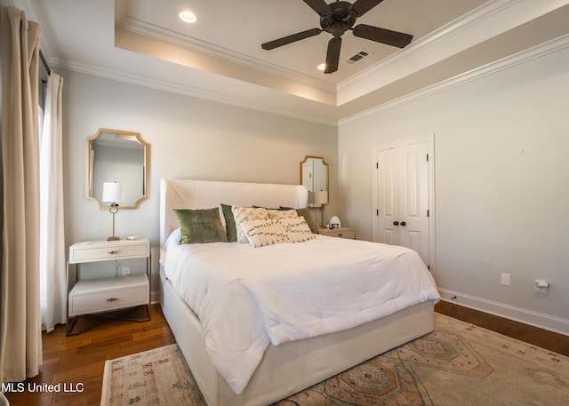 bedroom featuring a closet, a raised ceiling, ceiling fan, and dark hardwood / wood-style floors