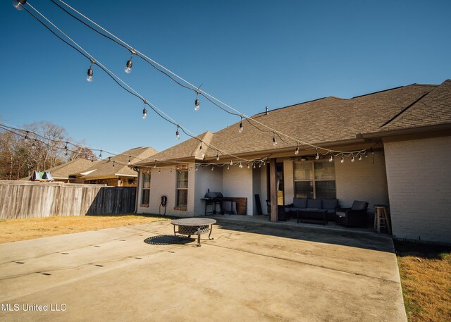 back of house with an outdoor living space and a patio