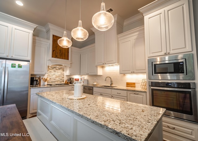 kitchen featuring decorative light fixtures, light stone counters, white cabinetry, and stainless steel appliances