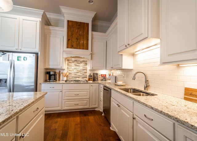 kitchen with decorative backsplash, white cabinetry, sink, and stainless steel appliances