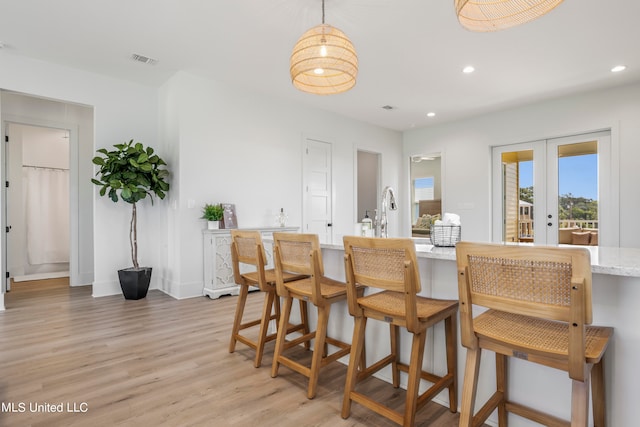 dining space featuring french doors and light hardwood / wood-style floors