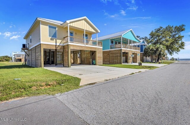 124 Arkansas Ave, Gulfport, MS 39507 - coastal inspired home with a carport, board and batten siding, driveway, and a front lawn
