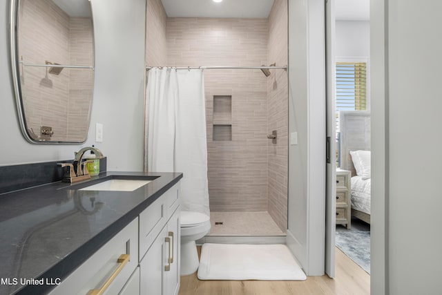 bathroom featuring vanity, walk in shower, hardwood / wood-style flooring, and toilet