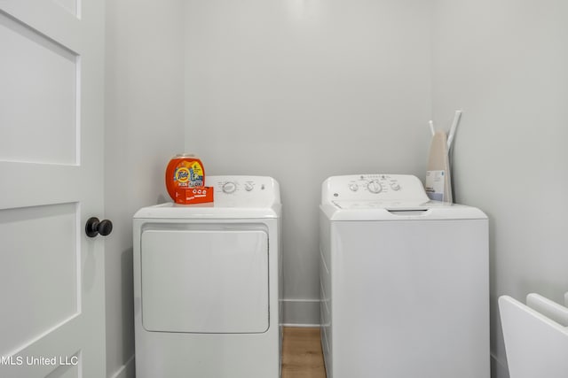 clothes washing area featuring hardwood / wood-style floors and washing machine and clothes dryer