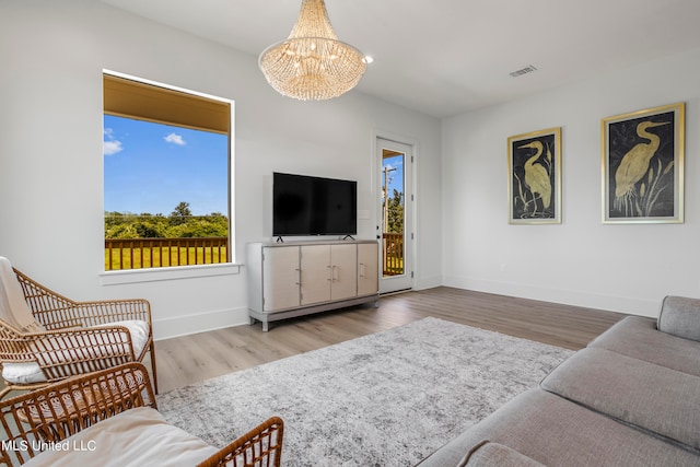 living room featuring a notable chandelier and light hardwood / wood-style flooring