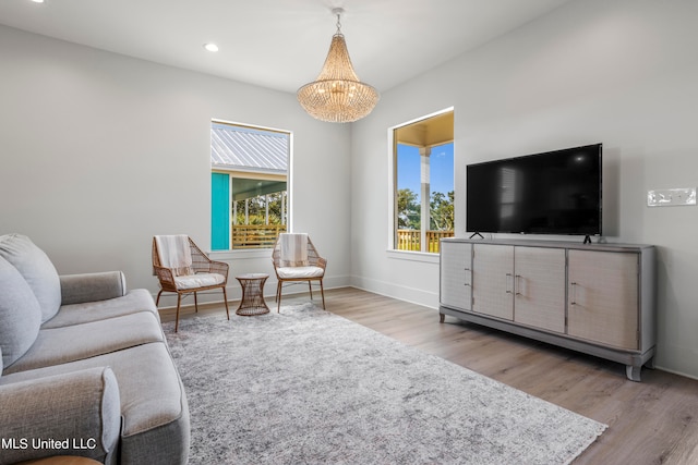 living room with an inviting chandelier and light hardwood / wood-style flooring