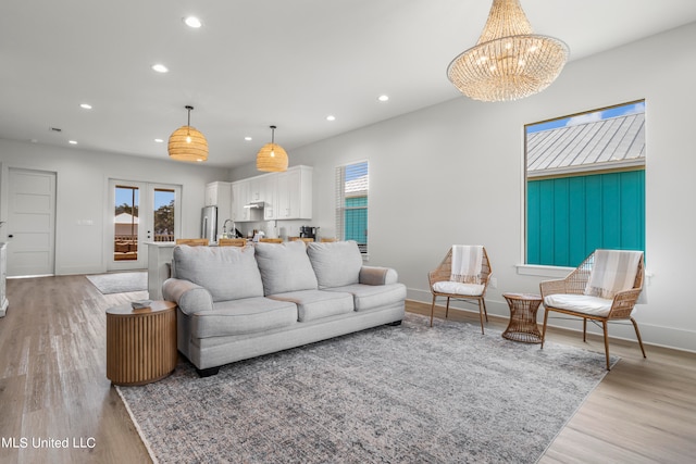 living room with a notable chandelier and light hardwood / wood-style floors