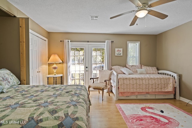 bedroom with light wood finished floors, access to outside, french doors, and visible vents