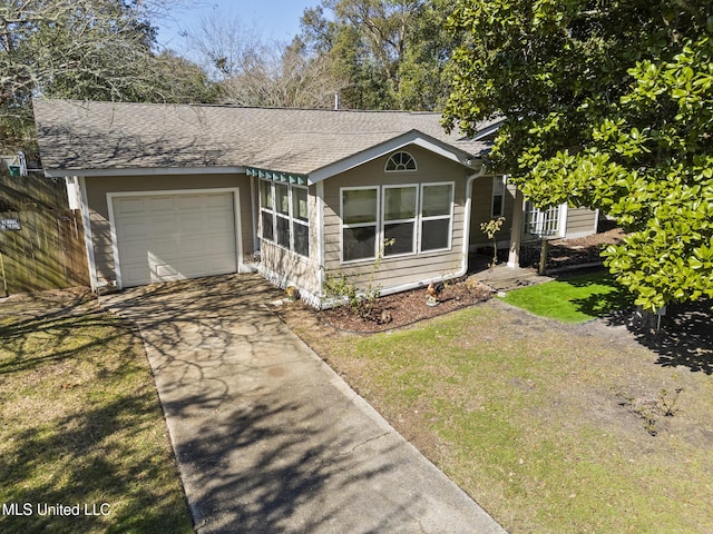 view of front of property with roof with shingles, an attached garage, fence, driveway, and a front lawn