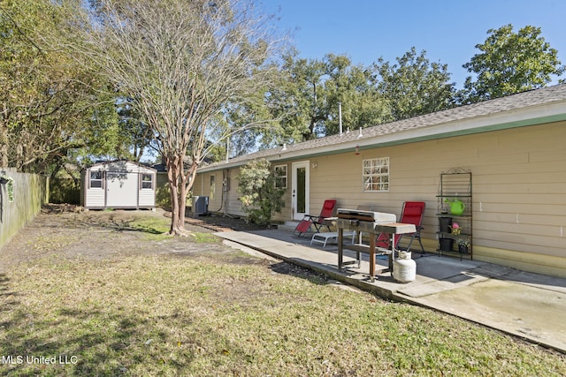 rear view of property with central AC unit, fence, an outdoor structure, a patio area, and a shed