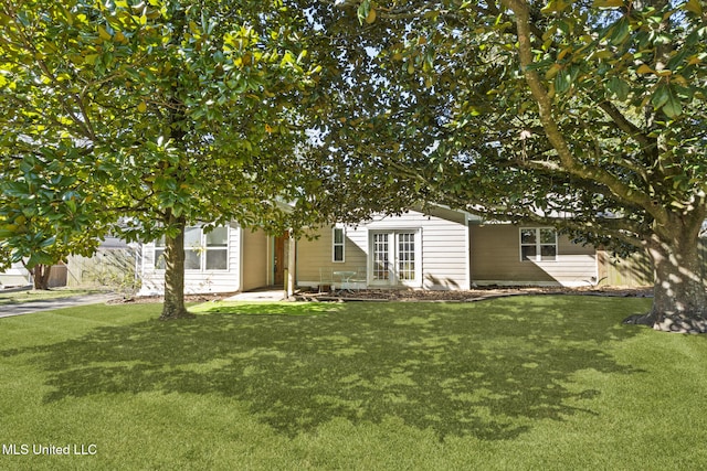 rear view of property featuring french doors and a yard