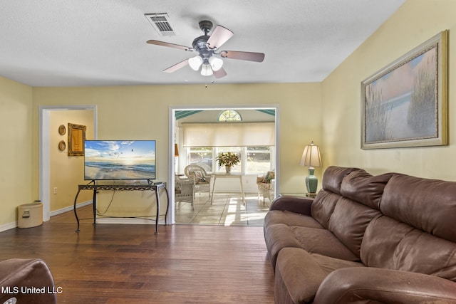 living room featuring visible vents, ceiling fan, a textured ceiling, and wood finished floors