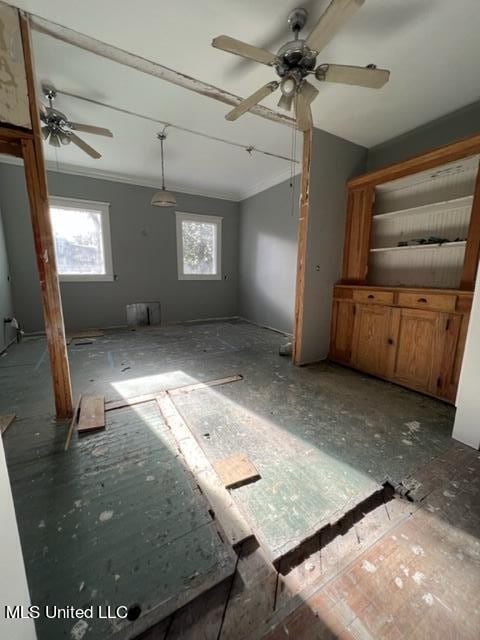 interior space with ornamental molding and ceiling fan